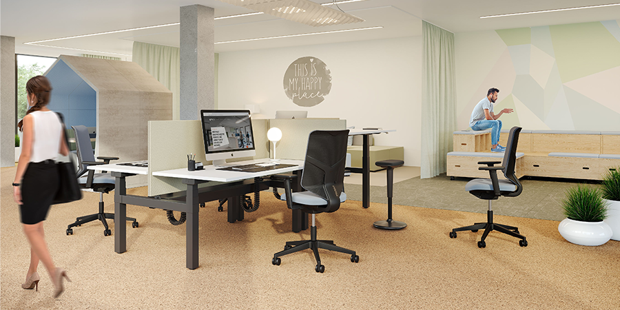 In einem offenen, hellen Büro, das von natürlichen Lichtquellen durchflutet wird, steht eine moderne Bench mit einem schwarzen Gestell und einer weißen Platte. Entlang der Schreibtische erstreckt sich eine beigefarbene Akustiktrennwand, die eine ruhige Arbeitsatmosphäre schafft. An den Arbeitsplätzen befinden sich zwei HUG.Y Bürostühle mit markanten schwarzen Rückenlehnen und grauen Sitzflächen.